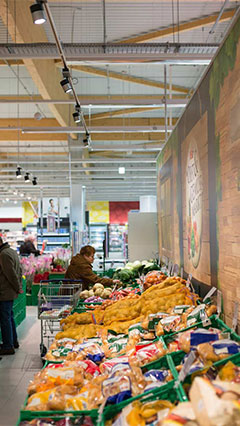 Customers looking at vegetables by the light of Philips fresh food lighting