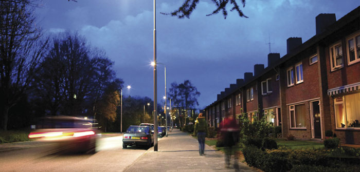 سيارات في أحد الشوارع المضاءة بفعالية بإضاءة Philips البيضاء