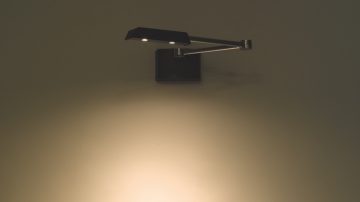 An adjustable lamp fixated at a wall