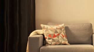 Cozy living room with modern LED table lamp, illuminating gray loveseat and creating warm ambiance for home relaxation.